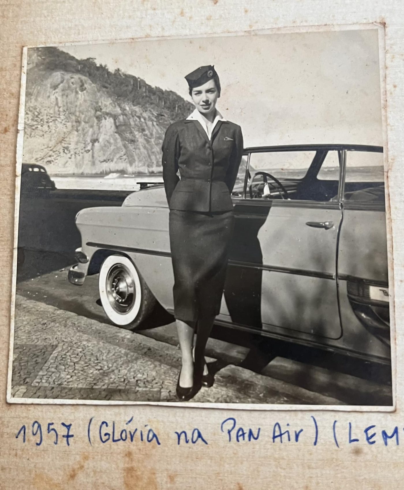 Fotografia de 1957 de uma mulher ao lado de um carro, no Leme