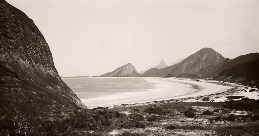 Fotografia antiga da Praia do Leme, ainda sem prédios, com o Morro do Leme à direita