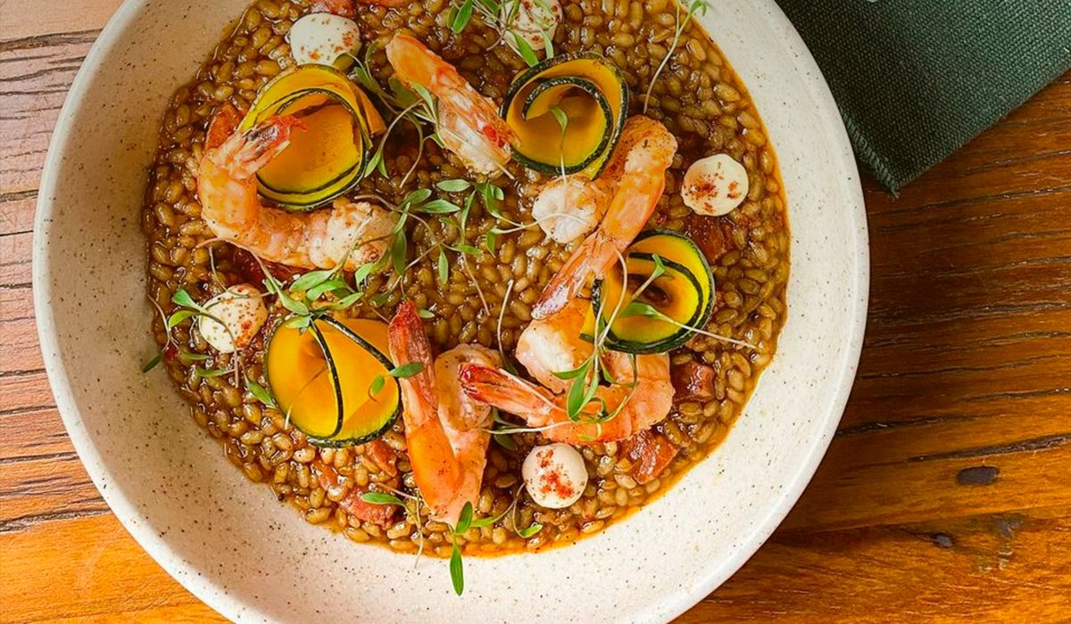 Prato do Joaquina: risoto com camarões, sobre a mesa de madeira do restaurante
